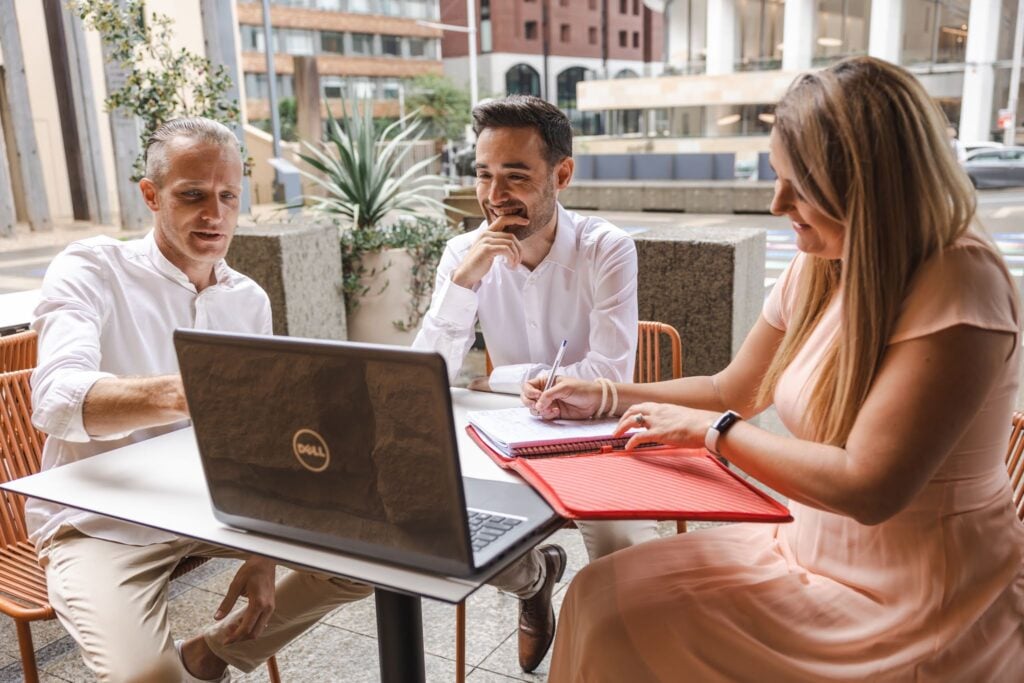three workmates enjoying business discussions in an outdoor place